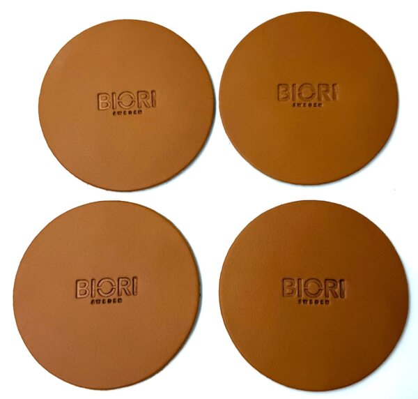 Glasunderlägg skinn Biori 5140C. Underläggen är runda och i cognac färg. De är vattenavstötande och säljs i förpackning om 4 st. Passar under de flesta öl och vinglas.
