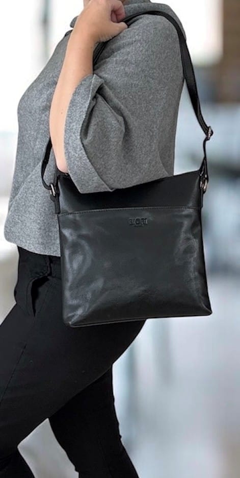 Svart handväska i skinn med justerbar axelrem från Biori Sweden, buren av modell