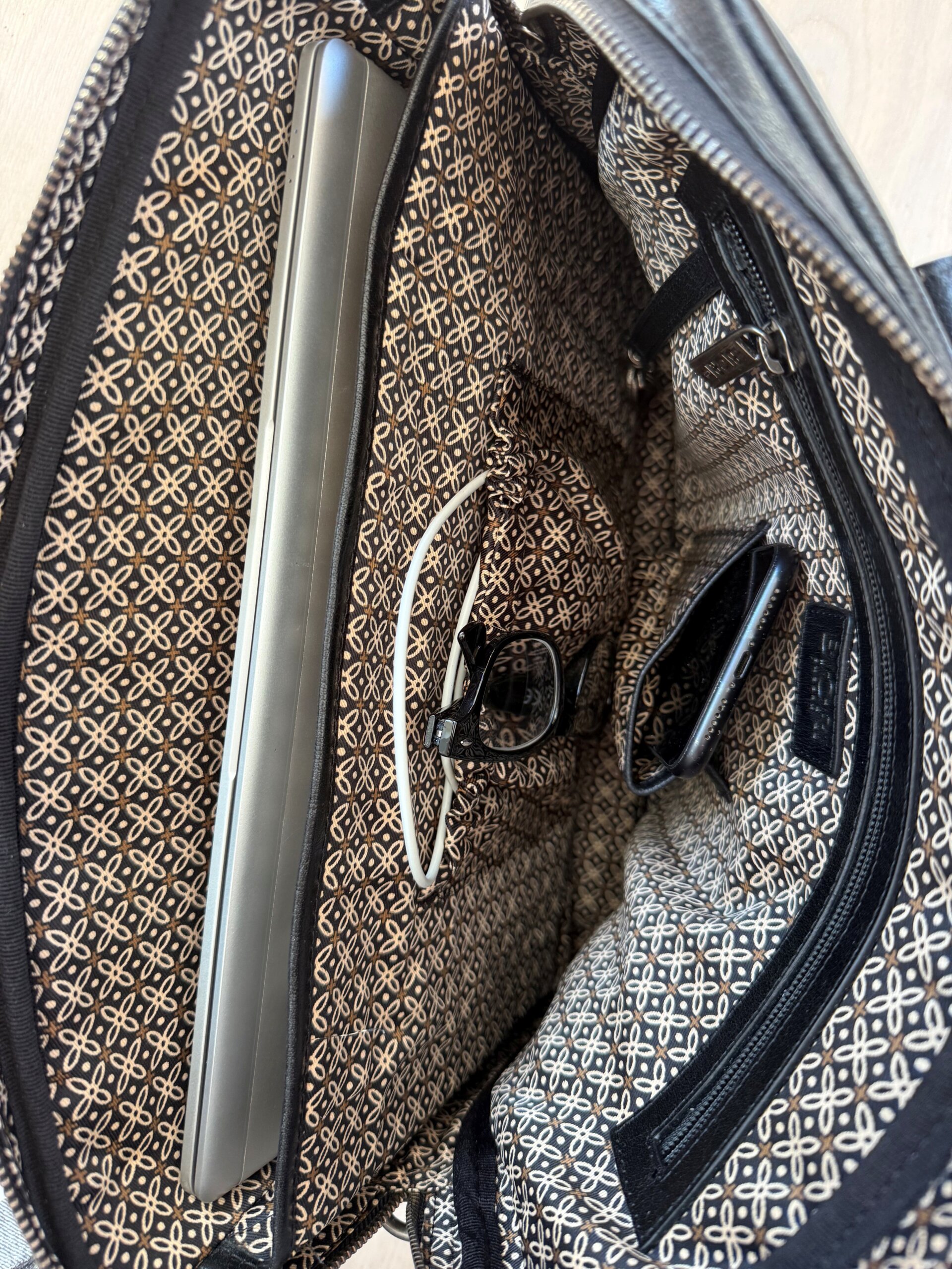 Inuti finns en vadderad ficka för en 14 tum laptop, en ficka med dragkedja för privata ting, en nyckelhållare samt fickor för mobil och laddare, axelremsväska herr, laptopväska dam, skinnväska herr, datorväska herr, portfölj läder, jobbväska dam skinn, biori laptopväska skinn, briori, biori väska, biori trophy, portfölj i läder, portfölj läder, portfölj herr, portfölj dam