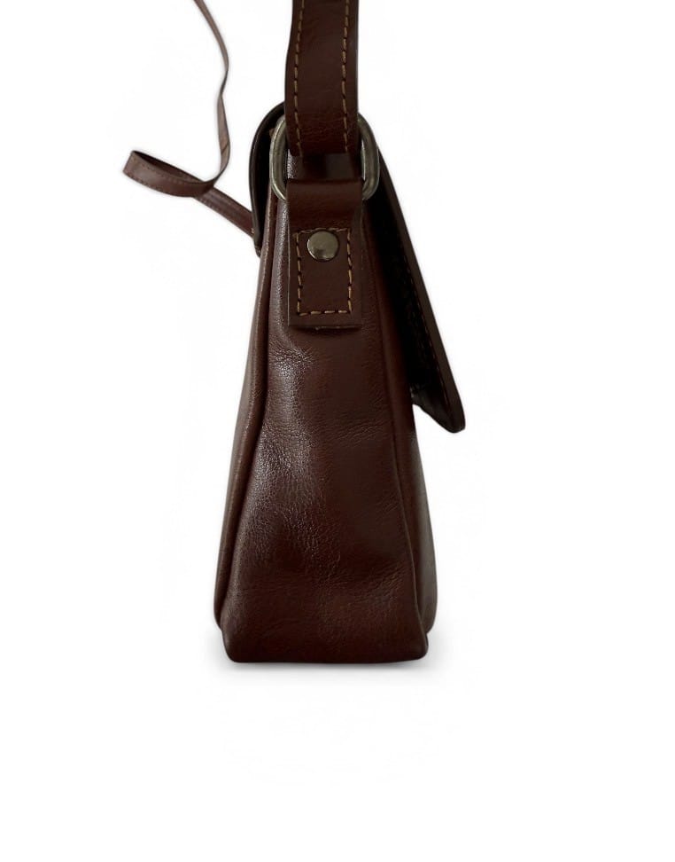 Sida av handväskan i brunt skinn där axelremmen fäster